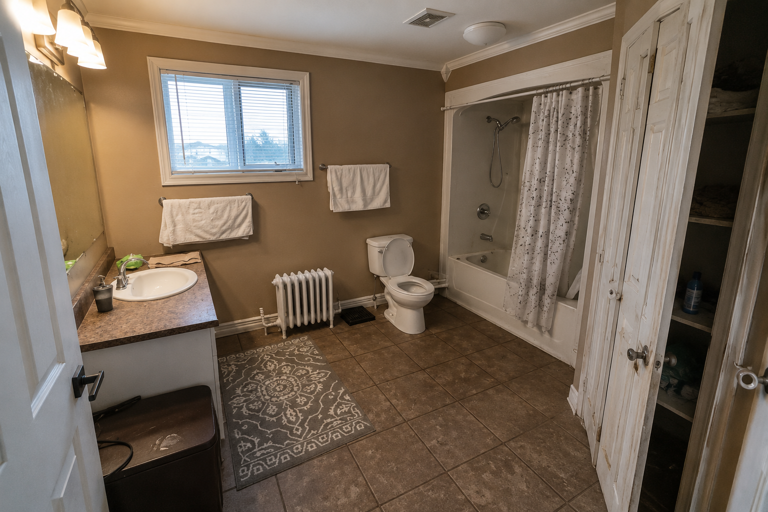 Bathroom before redesign, with a shower curtain, tiled floor and compact vanity